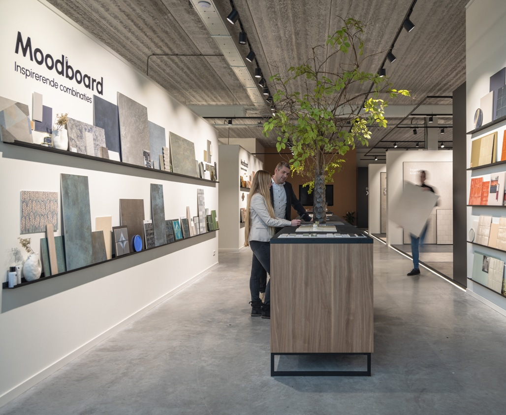 Lange wand met kleurrijke tegel moodboards in de showroom van TÉGL