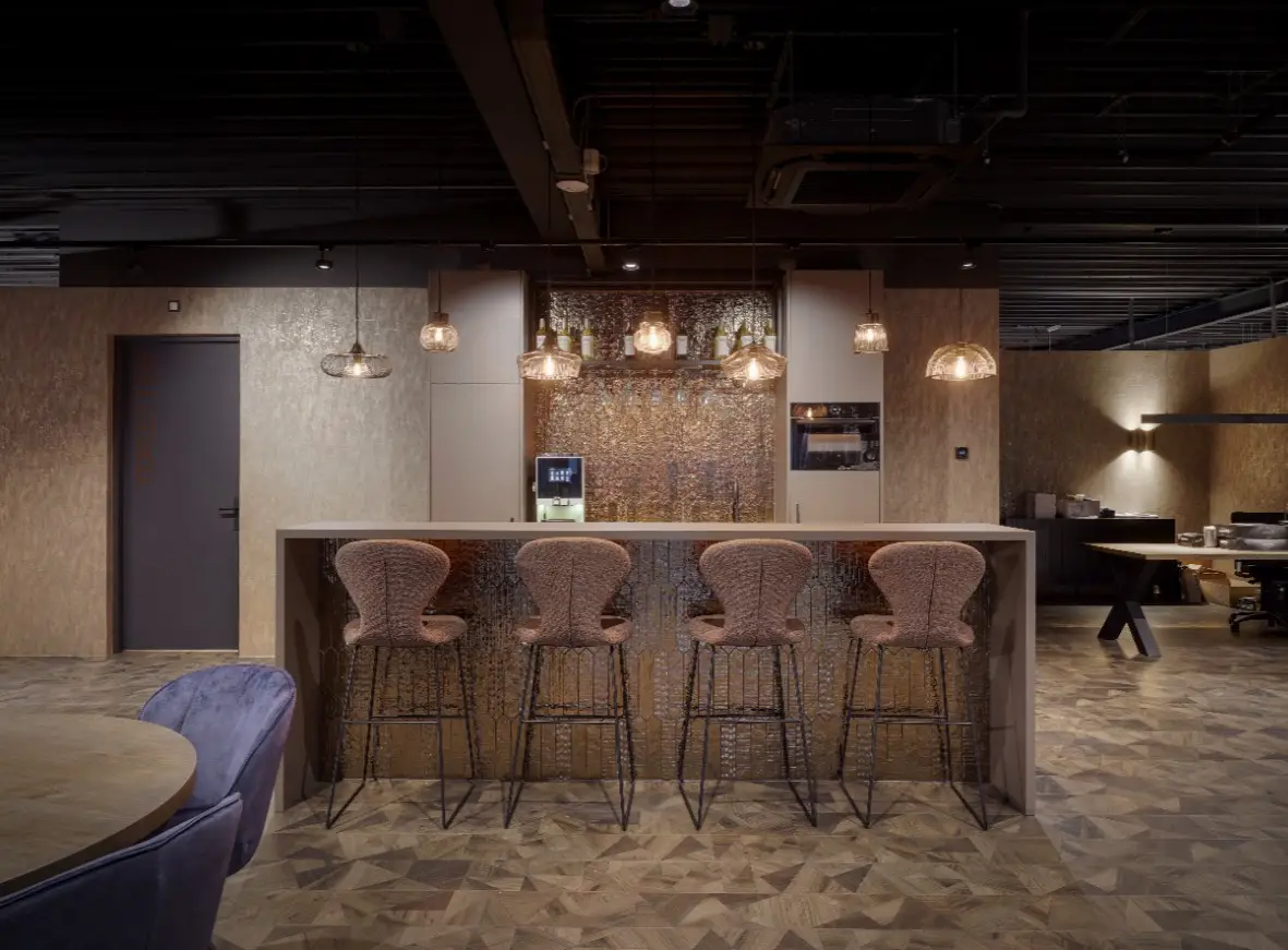 Impressie van een keuken met koffiecorner in een woonwinkel, voorzien van een nis met een achterwand van stijlvolle gouden keramische decortegels.