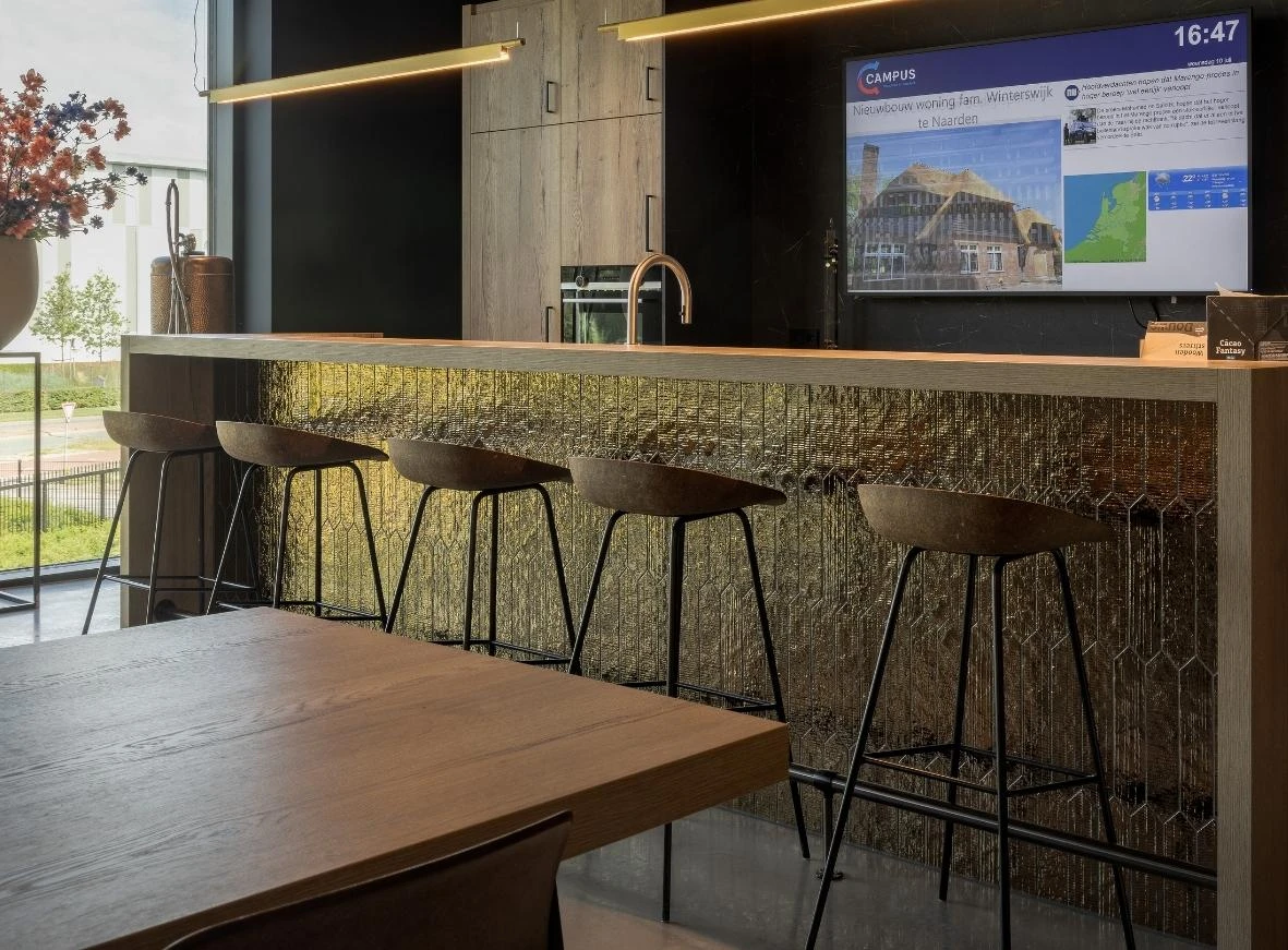 Impressie van een keuken in een bedrijfspand, voorzien van een bar met patroon tegels in de kleur goud.