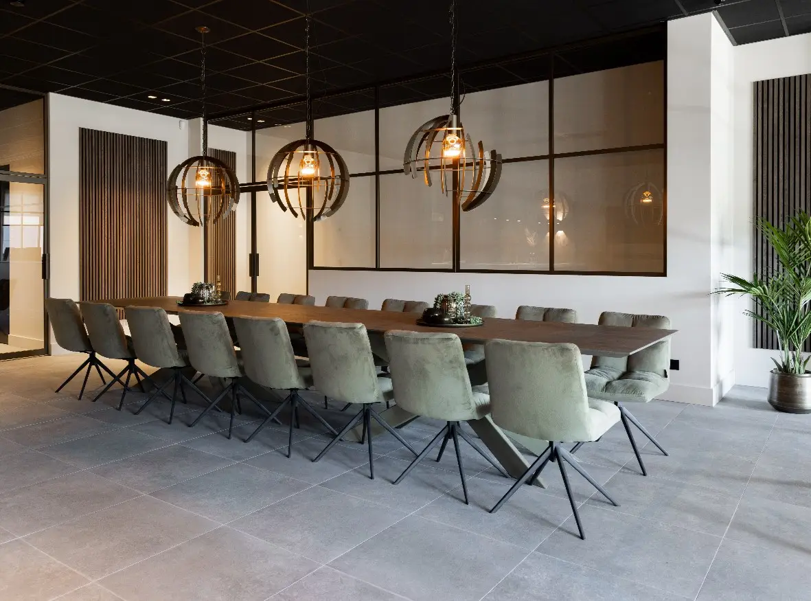 Impressie van een moderne vergaderruimte met een vloer van betonlook tegels.