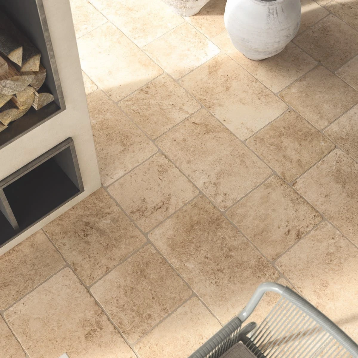 Buitenruimte met een landelijke vloer van rustieke tegels in warme aardetinten, witte potten en houtopslag voor een landelijke uitstraling.