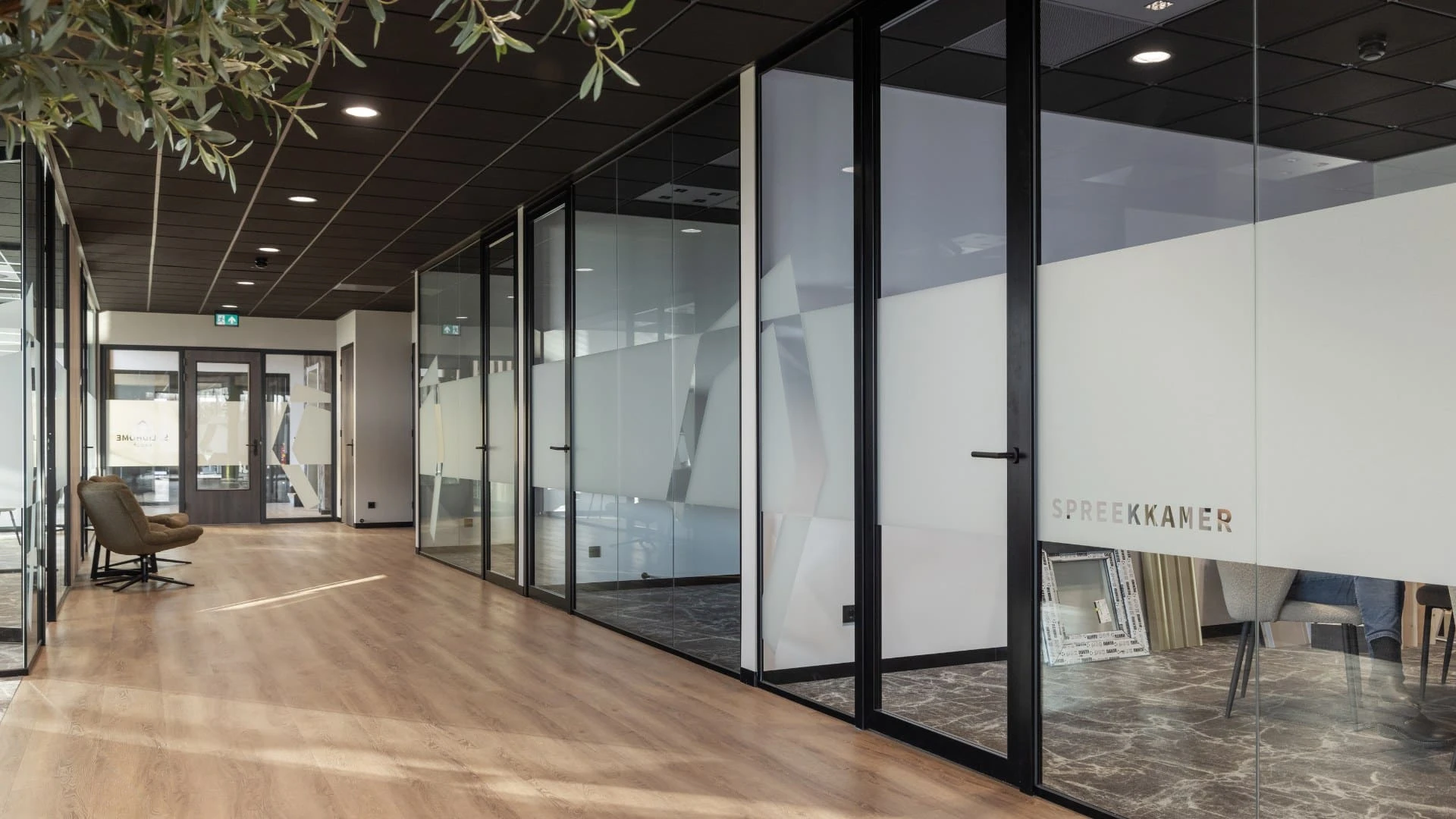 Bedrijfspand met werkruimtes en brede gang met keramische tegels houtlook