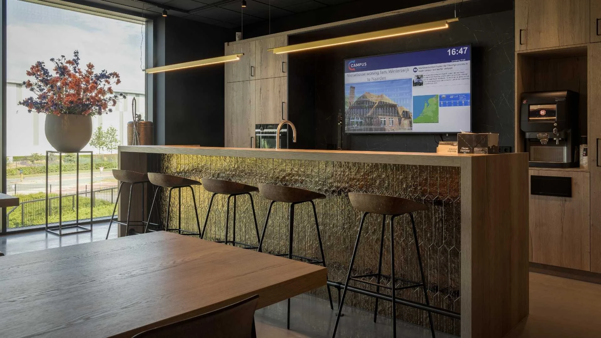 Impressie van een keuken in een bedrijfspand, voorzien van een bar met patroon tegels in de kleur goud.