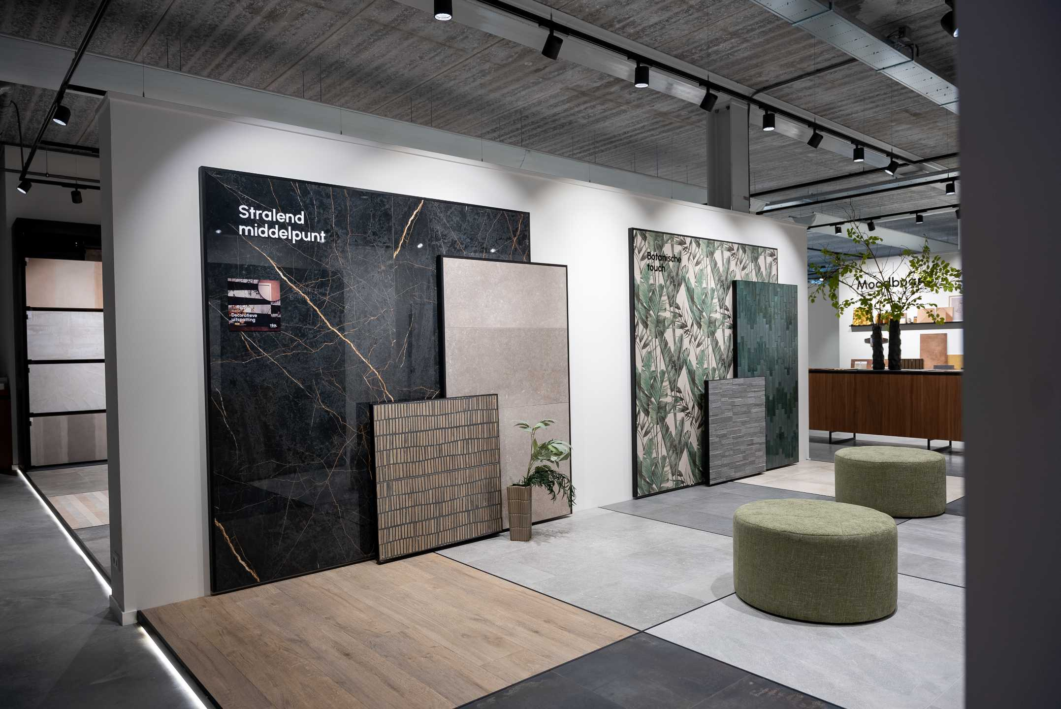 Groepjes van grootformaat tegels leunend tegen de muur in diverse soorten, maten en kleurtinten in de showroom van TÉGL